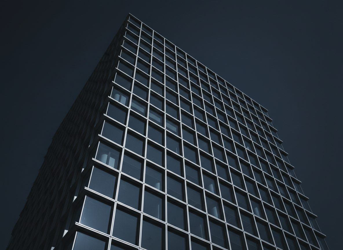 Abstract architectural photograph of a modern glass corporate office tower shot from a low upward angle against a dark charcoal sky, dramatic geometric grid of steel and glass facade, moody blue-grey tones, high contrast, no people, minimalist and authoritative, professional commercial real estate aesthetic